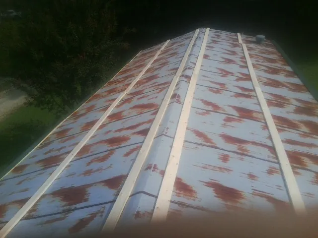 Rusted metal roof panels with new wood purlins before replacement — Storm Damage Roof Repair in Dewey by Roofing Brothers